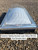 Wire exterior safety screen fitted over a Velux shrink-out smoke vent on a gravel roof, close-up