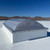 Velux CMD2 double dome skylight on a white roof, angled close-up with mountain view