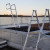 Two aluminum roof access ladders and a grated walkway installed on a rooftop at dusk