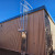 Aluminum KattSafe caged fixed ladder mounted on the exterior wall of a metal building