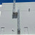 Tall caged fixed ladder with an intermediate landing platform on a gray warehouse wall