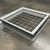 White primed roof curb with a pre-installed 4 inch on-center safety screen, shown on a warehouse floor