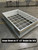Curbs Plus roof curb fitted with an optional 8-inch by 8-inch burglar bar grid, on a warehouse floor
