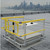 KattSafe yellow guardrail with self-closing gate surrounding a roof hatch, city skyline behind