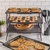 Three stacked gray cooling racks with baked pie, small cookies, and chocolate chip cookies