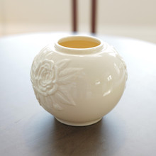 The sculptural raised florals catch light and cast subtle shadows across the vase's surface, creating a visual dance that brings dimension and interest even when the vessel remains empty.