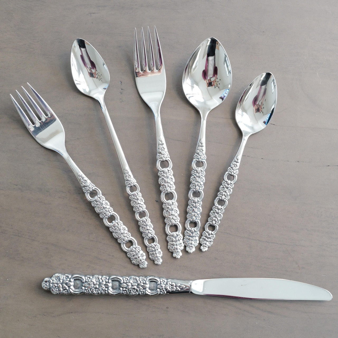 Wow! What a stunning set of vintage stainless steel flatware! The intricate detail on these handles is absolutely next level. Each piece boasts an ornate embossed floral pattern with elegant cutout details, creating a striking and sophisticated look that instantly elevates any table setting.