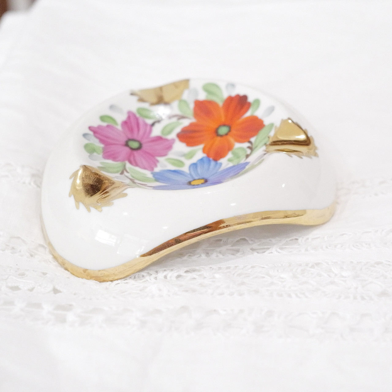 Merging function with artistic expression, this vintage porcelain piece jewelry dish captures mid-century sophistication through its harmonious blend of hand-painted florals and refined gold trim.