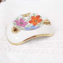 Merging function with artistic expression, this vintage porcelain piece jewelry dish captures mid-century sophistication through its harmonious blend of hand-painted florals and refined gold trim.