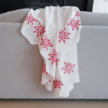 Vintage white linen tablecloth with red hand embroidered flowers.  The red floral design stands out against the white background of the tablecloth.  The back shows the floral design has been hand cross stitched.  Great for Christmas