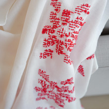 Vintage white linen tablecloth with red hand embroidered flowers.  The red floral design stands out against the white background of the tablecloth.  Close up of the back shows the floral design has been hand cross stitched.