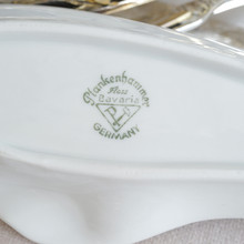 Close up of the back backstamp of a vintage white porcelain ashtray in an interesting organic oval shape.  The backstamp identifies the maker of the ashtray as Plankenhammer Floss Bavaria and the origin of manufacture as Germany.