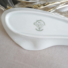 Left side of the back backstamp of a vintage white porcelain ashtray in an interesting organic oval shape.  The backstamp identifies the maker of the ashtray as Plankenhammer Floss Bavaria and the origin of manufacture as Germany.