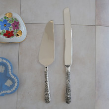 Vintage cake knife by Godinger .  Made with stainless steel blades and ornate silver plated handles.  These elegant pieces have a high gloss shine.  Excellent condition.