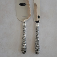 Vintage cake serving set with cake knife and cake server by Godinger .  Both serving utensils are made with stainless steel blades and ornate silver plated handles.  The elegant and ornate handles has a scroll and fan design.