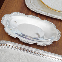 Classic and collectible, this Wallace Silversmiths silver-plated bread tray is part of the Royal Rose pattern introduced in 1962. Its intricate border and oval form make it an elegant serving piece for formal or casual occasions.