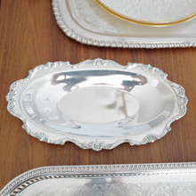 The Wallace Royal Rose 9807 bread tray is a stunning example of mid-century silverplate design. With its detailed raised floral motifs and high-shine finish, this piece adds vintage charm to any dining setting.