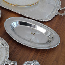 With a 12.5-inch length, this MSG Japan stainless steel tray offers ample space for serving bread, hors d'oeuvres, or fruit. Its gleaming surface and intricate border detail make it both functional and decorative.