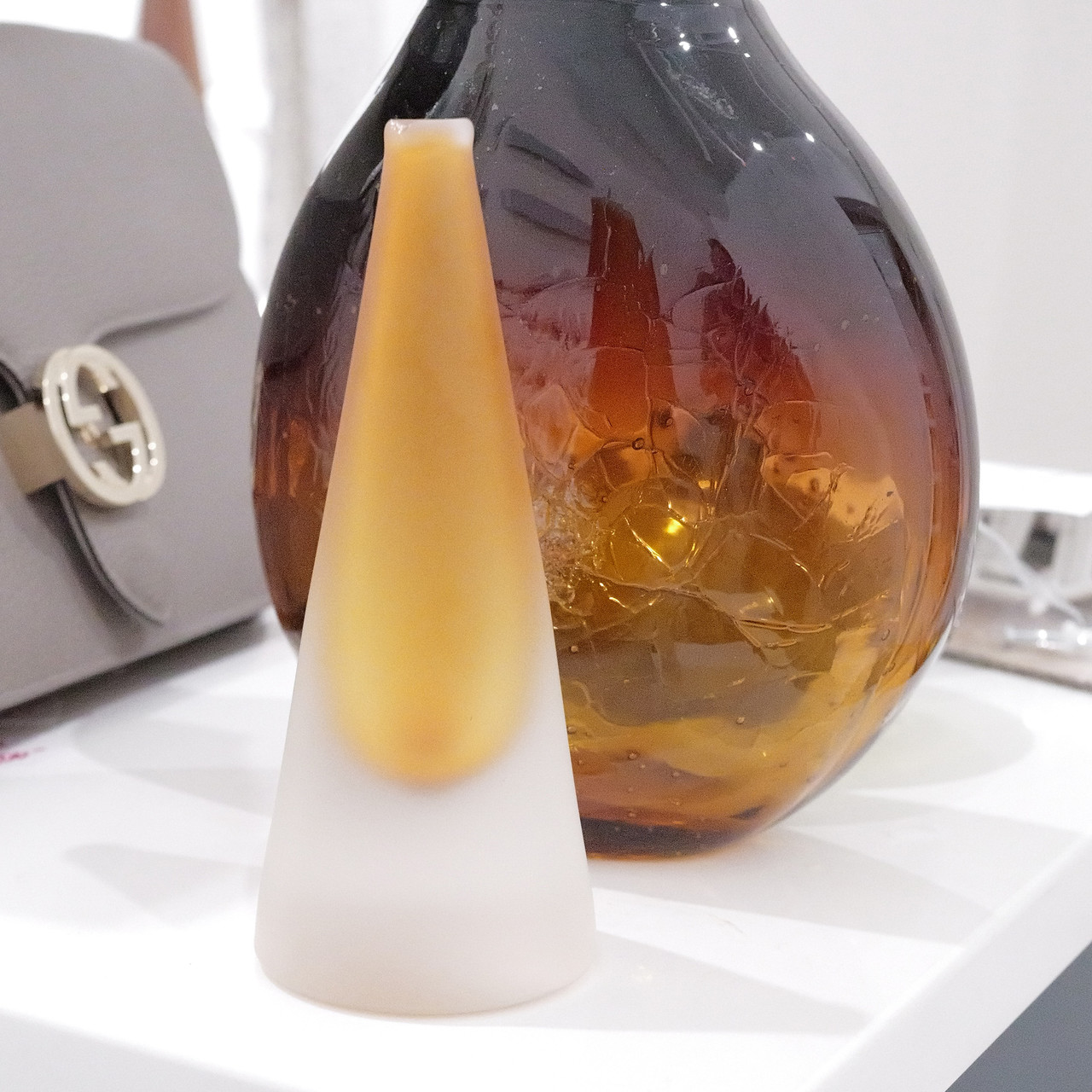 A striking mouth-blown scent bottle by Bob Crooks, showcasing smooth frosted glass with a warm amber gradient.