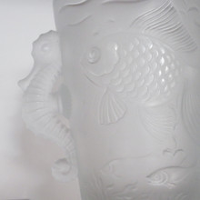 Delightful seahorse handles frame each side of this vase, adding a playful dimensional element that complements the swimming fish motif perfectly