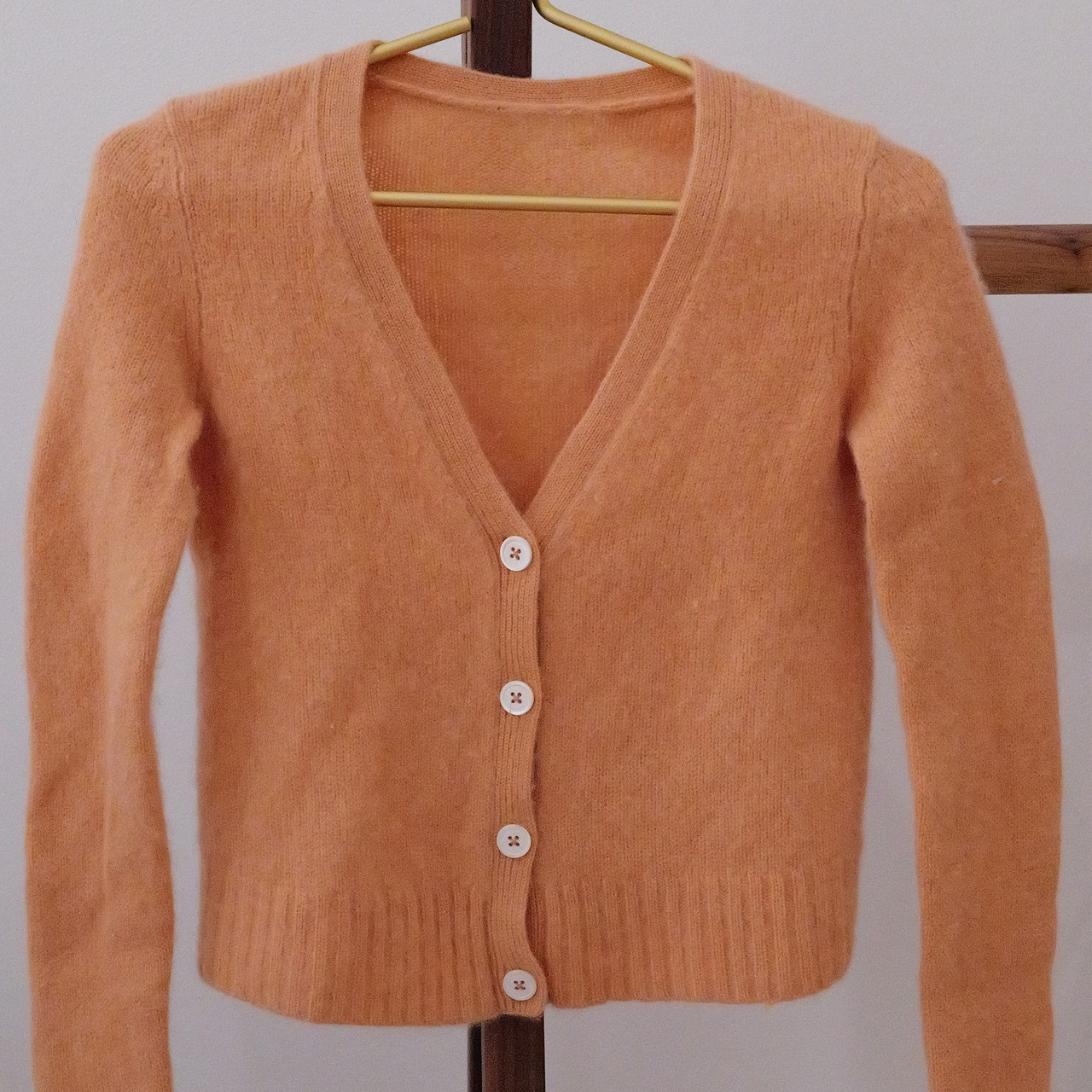 This vintage 100% cashmere cardigan is the perfect blend of softness and timeless style. This peach-orange cardigan is so soft and fuzzy.  Women's size extra-small (XS).