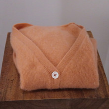 This vintage cashmere sweater features a classic V-neck and button front for timeless style.