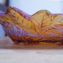 A stunning vintage iridescent bowl that shifts from gold to purple and blue in the light.