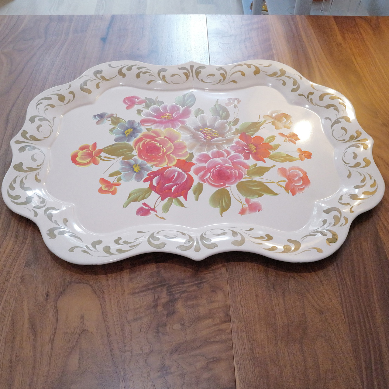This extra-large vintage metal tray features a bold hand-painted floral design with scalloped edges and gold scroll accents.