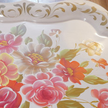 The ornate gold scrollwork around the scalloped edges enhances its old-world charm.