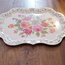 Hand-painted florals in pink, blue, yellow, and orange bring a burst of color to this vintage metal tray.