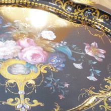 Black metal, gilded accents, and hand-finished florals make this English tray an eye-catching decorative piece.