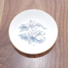 Features delicate blossoms in soft pastel hues with blue-green leaves.  Trimmed in elegant gold around the edge.