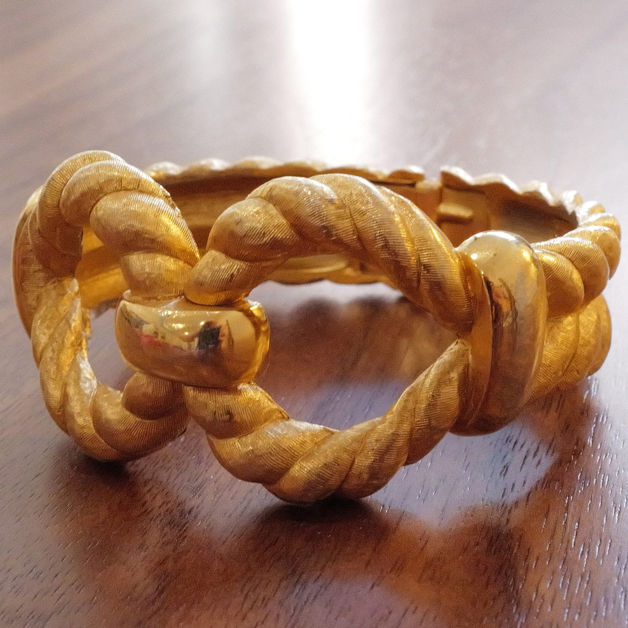 A vintage Trifari gold-tone bangle with hinged closure, perfect for timeless style.