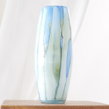 Vertical bands of color in ocean-inspired tones make this vase visually striking. The smooth glass amplifies the movement within the design.