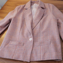 Features a single-button closure for a classic look.  The jacket shape has a boxy structured look.