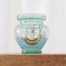 Blown glass vase with a painted scene depicting sail boats on the water.