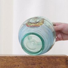 Vintage blown glass vase.  The glass has a blue green tint.  There is a scene of sailboats painted on the vase.