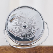 The top of this vintage ice bucket is shiny chrome with a starburst pattern