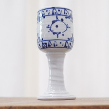 This vintage stoneware water goblet has a white glaze that's not quite matte but not glossy, and an abstract design in blue.