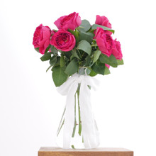 Fresh floral arrangement of one dozen garden roses in a stunning magenta color.