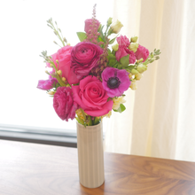 Seasonal flower arrangement of purple anemone and hot pink roses.