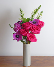 Purple anemone and hot pink roses mixed with other deep pinks and bright purple flowers make the vibes on this arrangment.