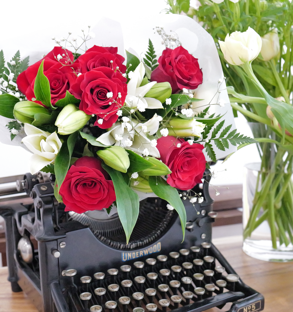 White lilies, red roses, babies breath, and greenery come together in a classic combination.