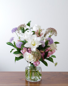 Sweet Baby Girl arrangement featuring soft pink, lavender, and white flowers in a clear glass vase.