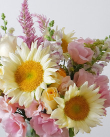 Summer, bottled. Soft pinks, buttery yellows, and sunflowers in an effortless garden-inspired arrangement.
