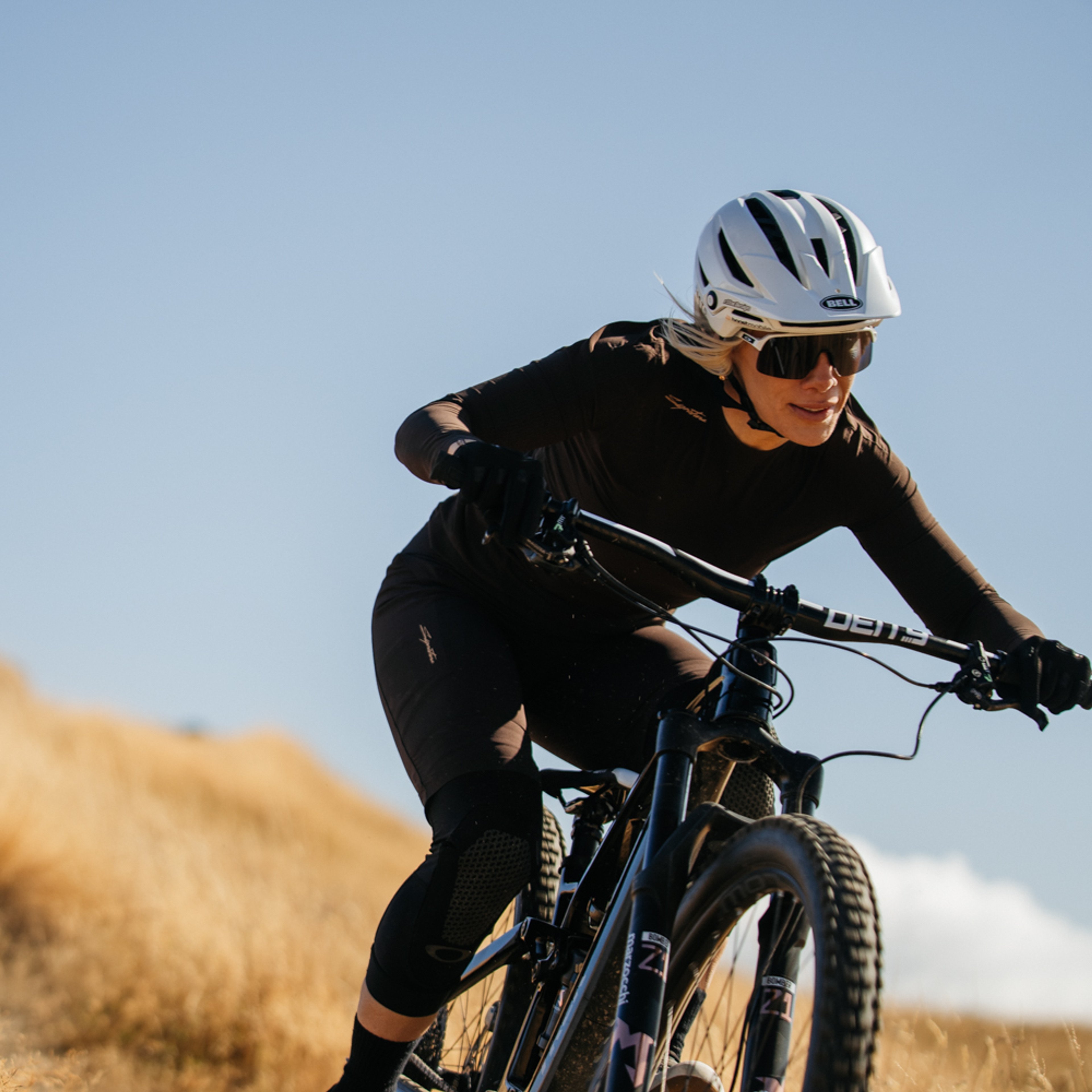 female mountain biker descending wearing a chocolate torte colored jersey