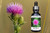 Bull Thistle Flower Essence bottle beside a Bull thistle flower