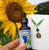Image of a flower essence and necklace by a sunflower