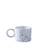 Enjoy your morning cup of coffee or tea in the unique "Bague" mug by TUTU Home. Handmade with love, this ceramic mug features a large ring handle and a stunning ink splash pattern, making it a stylish addition to your morning routine.