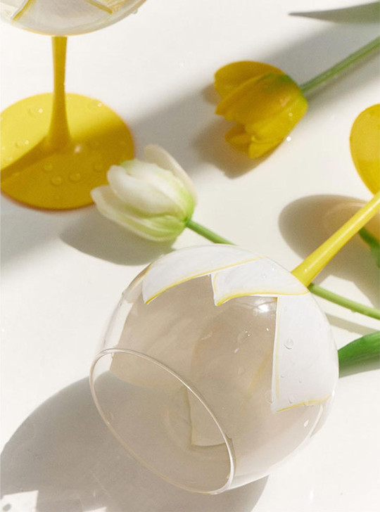 glass with white flower and yellow stem